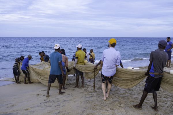 Felix trägt mit den Bewohnern ein Fangnetz ins Meer