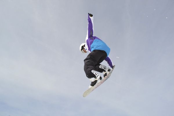 Sandro fliegt mit dem Snowboard durch die Luft