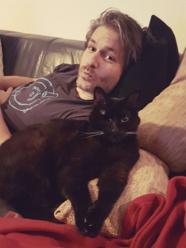 Tobias liegt auf dem Sofa mit seiner schwarzen Katze